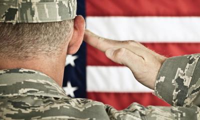 Military soldier saluting American flag